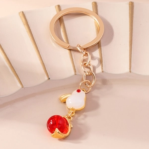 Macro detail of the golden zodiac rabbit keychain with imitation jade resin and red bead