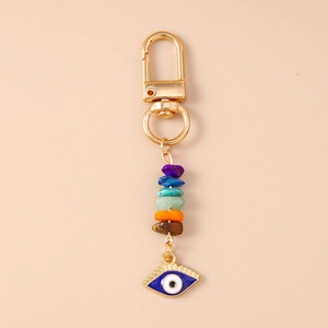 Detail of evil eye keychain featuring colorful stones and gold lobster clasp charm