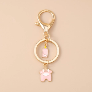 Detailed macro view of the golden lobster clasp and pink baby bottle keychain pendant