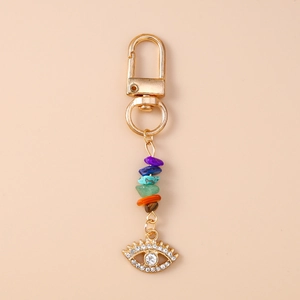 Detail of evil eye keychain with gold plating, colorful natural stones and rhinestones