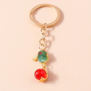 Close-up of golden lantern rabbit keychain with green jade bird and red bead detail