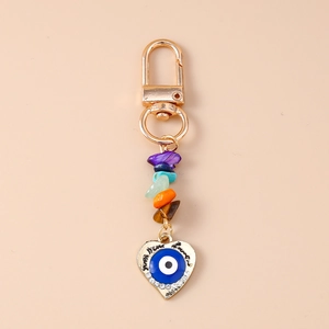Close-up of heart devil eye keychain with colorful natural stones and gold metal clip