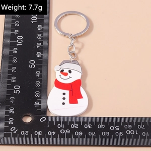Detail view of snowman keychain with red scarf and measurement scale, weighing 7.7g