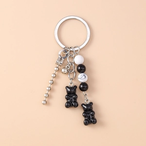 Detail of beaded bear keychain with dice beads, metal chain, and glossy resin charms