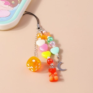 Détail de dragonne de téléphone perlée avec ours en résine, perles coeur et pendentif dé