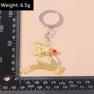Detail view of a golden reindeer keychain with a red nose being measured on a scale