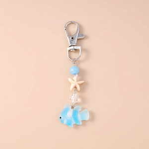 Détail d'un porte-clés thème marin avec breloques étoile de mer et poisson clown bleu
