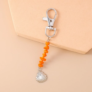 Detail of silver lobster clasp with orange stone beads and a scallop shell pendant charm