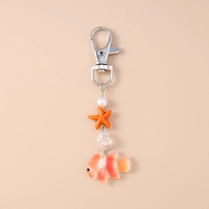 Détail du porte-clés poisson-clown avec étoile de mer, perle et fermoir mousqueton argenté