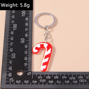 Detailed view of a red and white candy cane keychain weighing 5.8g on a measuring scale