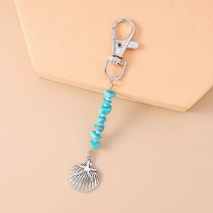 Detail of silver alloy keychain with turquoise beads and scallop starfish charms