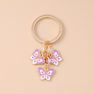 Dettaglio del portachiavi a farfalla viola con anello dorato e finitura smalto