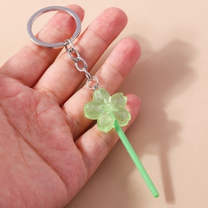 Detailed view of light green sakura lollipop keychain with colorful glitter resin