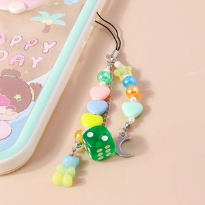 Détail de la dragonne de téléphone avec dé vert, lune et ours en dégradé de couleur