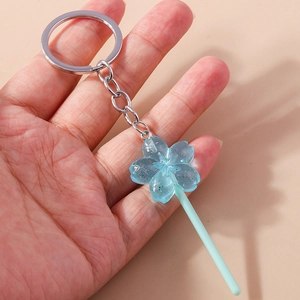 Close-up of a blue cherry blossom lollipop keychain with glitter and silver metal ring