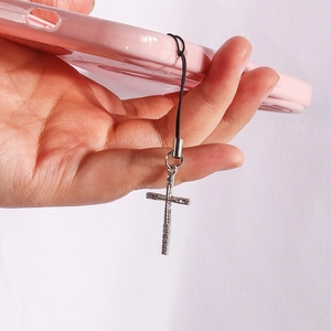 Gothic silver cross phone charm with metallic texture attached to a pink case