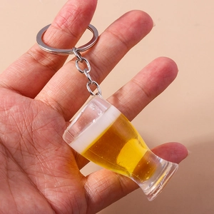 Porte-clés créatif en forme de chope de bière avec mousse réaliste tenu à la main