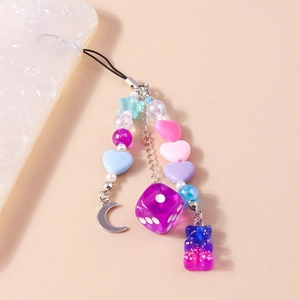 Détail de dragonne pour téléphone avec ours en résine, dés mauves et perles de cœur