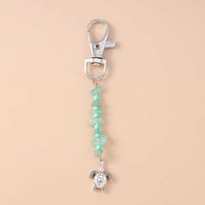 Detailed view of turtle keychain with aventurine stones and silver lobster clasp accessory
