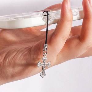 Close-up of gothic silver cross phone charm with white rhinestones on a clear case