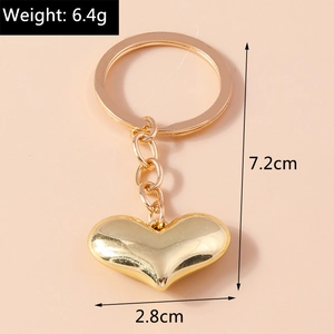 Detail view of a gold 3D heart keychain showing 7.2cm length and 6.4g weight