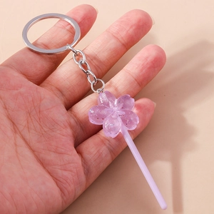 Detail of purple cherry blossom lollipop keychain in resin with glitters and silver ring
