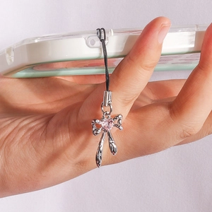 Detailed shot of silver bow phone charm with a pink crystal heart on a clear case
