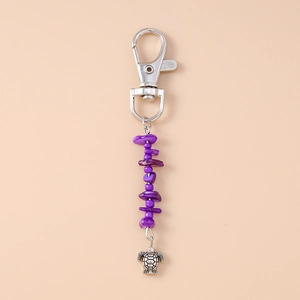 Close-up of vintage keychain with purple natural stones and silver turtle charm pendant