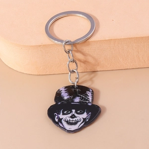 Macro shot of a Halloween skull keychain with top hat and silver metal ring and chain