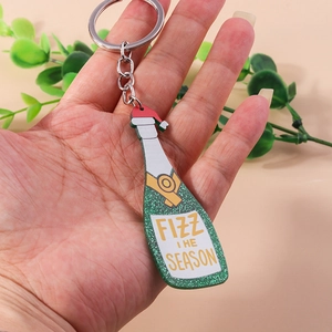 Detailed close-up of champagne bottle keychain with green glitter and Christmas hat