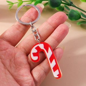 Detail of a red and white striped Christmas candy cane keychain with a silver ring