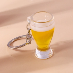 Gros plan sur porte-clés chope de bière avec liquide et mousse sur fond beige clair