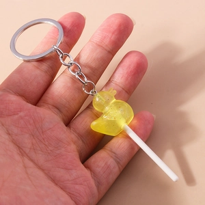 Detailed view of yellow duck lollipop keychain with resin glitter held in hand