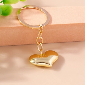 Close-up of heart-shaped 3D metal keychain with polished gold finish and elegant link chain