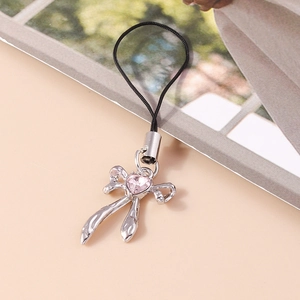 Close-up of silver ribbon bow phone charm featuring a pink heart-shaped crystal stone