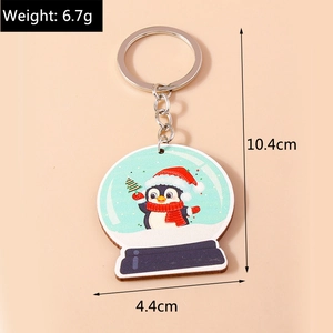 Détail du porte-clés globe de neige pingouin avec dimensions de 10,4 cm par 4,4 cm