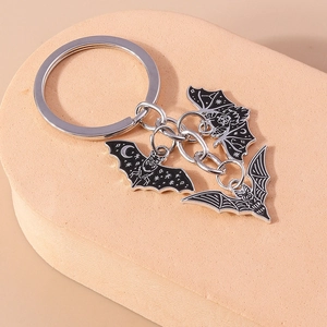 Détail de trois pendentifs chauve-souris en émail noir avec motifs de lune et d'étoiles