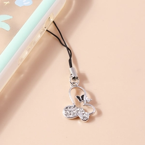Macro detail of a silver butterfly phone charm with rhinestones on a mint green case