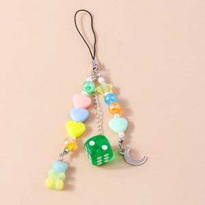 Détail de dragonne de téléphone colorée avec ours et perles sur surface beige