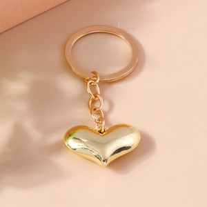 Detailed close-up of polished gold heart-shaped keychain with reflective surface