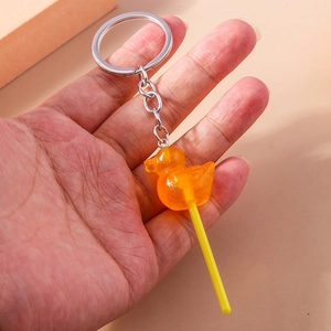 Detailed close-up of a resin duck lollipop keychain with glitter and silver metal ring