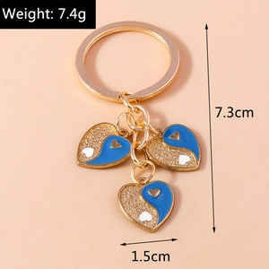 Vue détaillée du porte-clés Yin Yang en forme de cœur avec émail bleu et paillettes