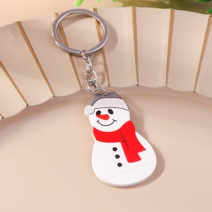 Detailed close-up of a festive snowman keychain with red scarf on a ceramic tray