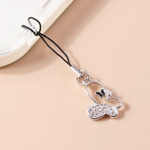 Detailed view of heart and butterfly phone charm with sparkling rhinestones and black enamel