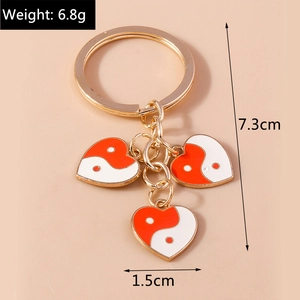 Détail d'un porte-clés Tai Chi doré en forme de cœur avec mesure de longueur de 7,3 cm