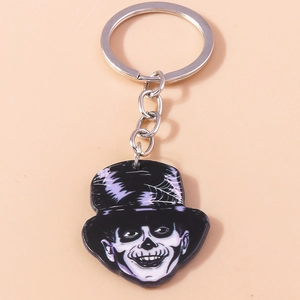 Close-up of Halloween keychain featuring skeleton figure in purple spider web top hat