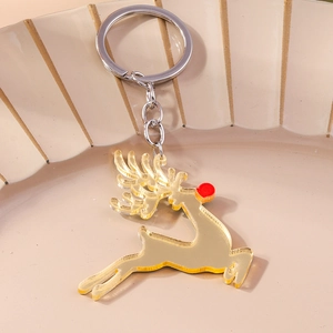 Detail of a golden mirror acrylic reindeer keychain on a beige ceramic tray