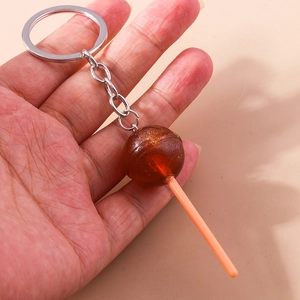 Close-up of creative brown glitter lollipop keychain with orange handle and silver ring