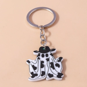 Gros plan du porte-clés fantôme en acrylique avec chapeau motif vache sur fond rose