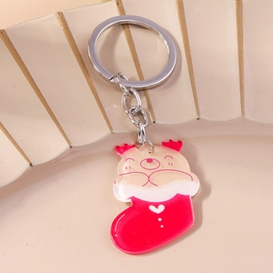 Detailed view of a cute Christmas bear in a red stocking keychain on a ceramic plate